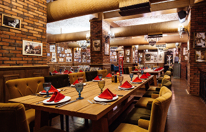 restaurant-hall-with-red-brick-walls-wooden-tables-pipes-ceiling (1)